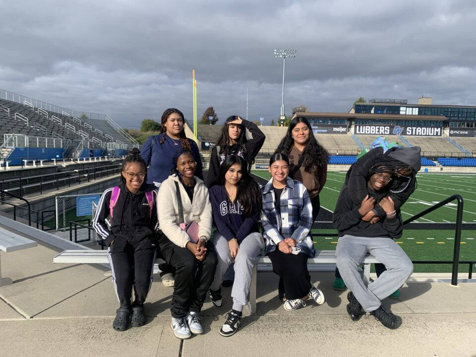 Charter school students sitting on a bench inside of Lubbers Stadium